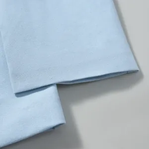 Close-up detail showing the cuff and linen texture of a light blue blazer