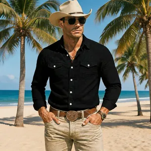 Close-up lifestyle shot of a man wearing a black long-sleeve cotton linen shirt on the beach