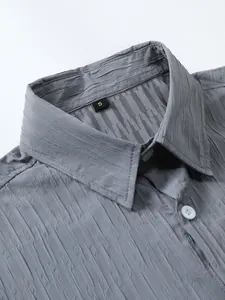 Close-up detail of grey textured fabric and collar on a men's short sleeve shirt.