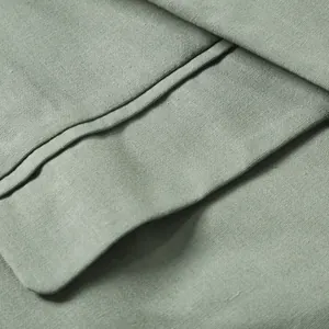 Macro view of sage green cotton linen suit jacket fabric texture and fine stitching detail