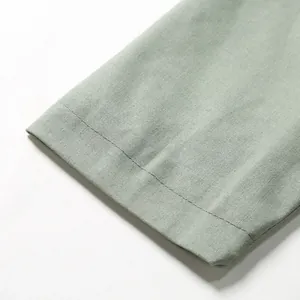 Detailed close-up showing the sleeve cuff and woven texture of a men's sage green linen blazer.