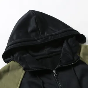 Close-up of the metal zipper and hood detail on a men's color-block hooded sweatshirt