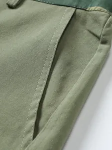 Close-up detail of men's cargo shorts showing pocket stitching and twill fabric texture