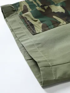Close-up of olive green cargo shorts showing high-quality stitching and camo detail