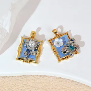 Gros plan de pendentifs vintage en émail bleu avec fleur de perle et motif papillon.