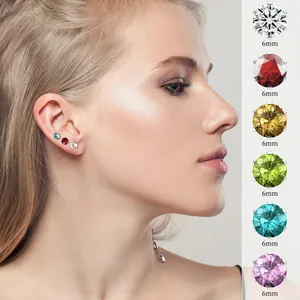 Detalle de pendientes de circonita multicolor de 6mm en acero inoxidable sobre modelo