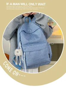 Detailansicht des blau karierten Schulrucksacks mit süßem Plüsch-Anhänger.