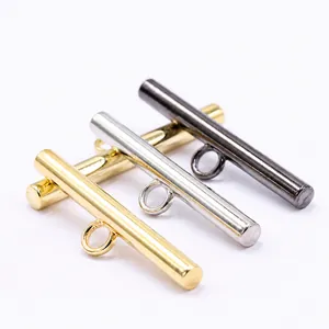 Close-up of sleek metal bar shank buttons in gold, silver, and gunmetal gray finishes