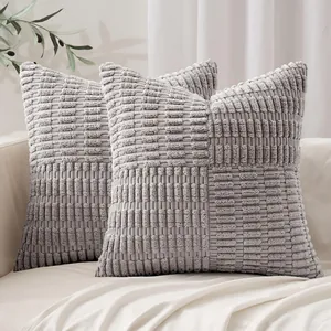 Close-up of two grey corn kernel textured decorative pillow covers on a white sofa