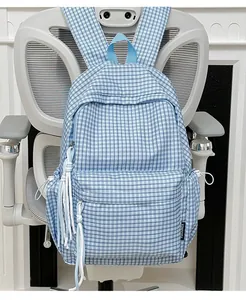 Detailansicht eines blau-weiß karierten Studentenrucksacks mit Quasten-Dekoration