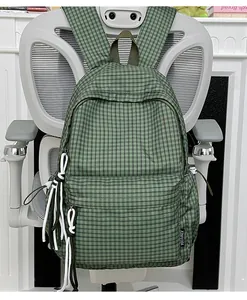 Grüner karierter Schülerrucksack mit großem Fassungsvermögen und Zierquasten.