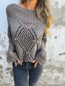 Vue rapprochée montrant la texture détaillée et les motifs ajourés du pull en maille