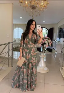Elegant olive green V-neck long dress with peach leaf print in a lifestyle setting