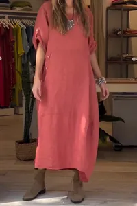 Detail view of loose coral cotton linen dress featuring side pockets and button accents