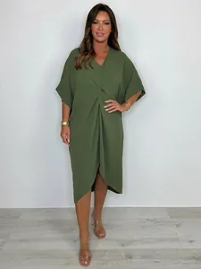 Detailed view of olive green oversized dress with front knot and asymmetrical hem