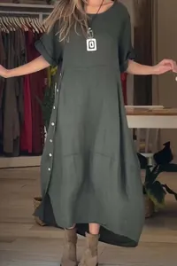 Detail view of loose dark green cotton linen dress with side button accents and midi length.