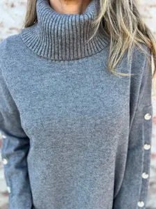 Detail eines grauen Rollkragenpullovers mit Rippkragen und weicher Strickstruktur.