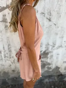 Side view of pink cotton linen romper with spaghetti straps and bow tie back detail