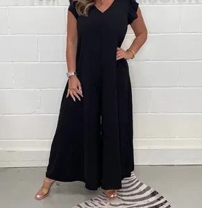 Vue complète d'une combinaison noire à col en V et jambes larges sur un mannequin.