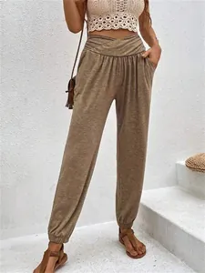 Detail shot of stylish high-waisted loose jogger pants with pockets in earthy brown