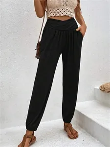 Detail view of black high waisted harem pants with crossover waist and side pockets