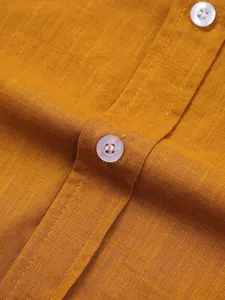 Primer plano de la textura de lino ocre con botones blancos y costuras finas