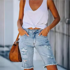 Bermuda en jean délavé clair pour femme avec des détails déchirés et un ourlet brut.