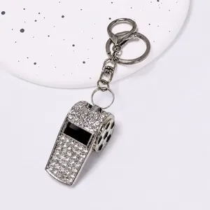 Vista dettagliata di un portachiavi a fischietto in strass argento con motivo calcio.