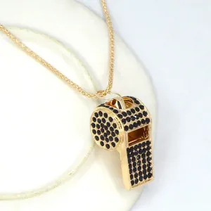 Vista dettagliata del ciondolo a fischietto d'oro con strass neri per accessori di moda