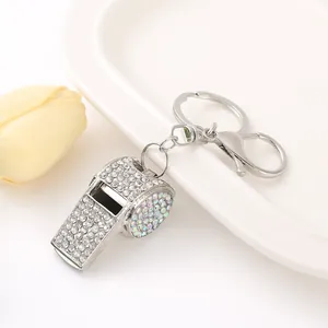 Primo piano di un portachiavi a fischietto con strass scintillanti e moschettone.