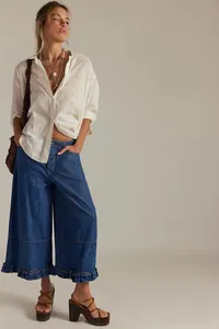 Full-body view of women's wide-leg cropped jeans with chic feminine ruffle hem details
