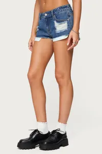 Pantaloncini di jeans a vita bassa con strappi e orlo sfrangiato per lo stile streetwear.