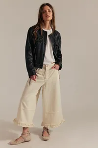 Full length view of cream wide-leg cropped jeans with feminine ruffle hem detail