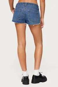 Vista posteriore dettagliata di pantaloncini in denim blu lavato a vita bassa con orlo a vivo