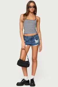 Pantaloncini di jeans a vita bassa strappati da donna, stile urbano estivo.