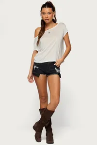 Vista a figura intera di pantaloncini di jeans a vita bassa con top bianco a spalle scoperte