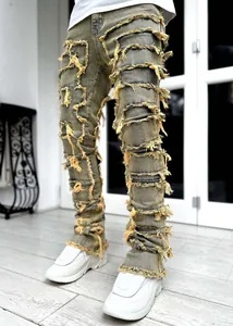 Λεπτομερής άποψη ανδρικού τζιν streetwear με κίτρινα ξεφτισμένα μπαλώματα και ίσια γραμμή.