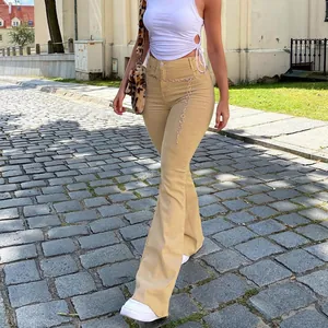 Detailed shot of khaki high-waisted flared trousers showing slim fit and street style look