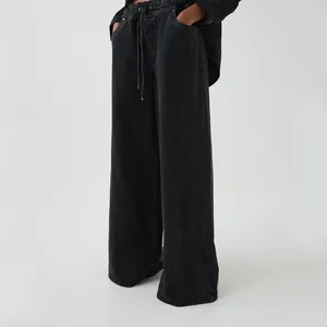 Detail of women's black washed wide-leg denim pants with drawstring waist