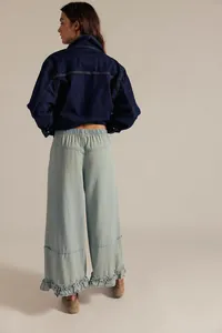 Back view of women's light blue wide-leg cropped jeans with ruffled hem detail.