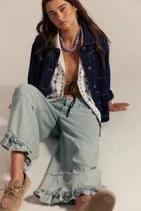 Detailed view of women's light blue wide-leg cropped jeans featuring stylish ruffle hems.