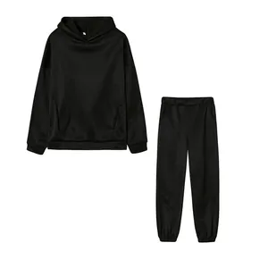 Dettaglio di una tuta nera a due pezzi con felpa con cappuccio e pantaloni sportivi.