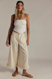 Full body detail view of women's cream wide-leg jeans showcasing the stylish ruffled hem