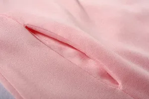 Primo piano della tasca della felpa rosa con trama del tessuto morbida e cuciture curate
