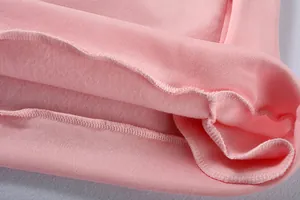 Primo piano di felpa rosa che mostra la morbida fodera in pile e le cuciture dell'orlo.