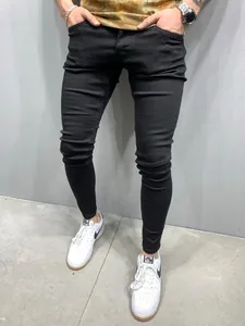 Detail shot of men's slim fit black stretch skinny jeans styled with white sneakers