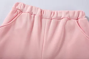 Vista dettagliata dei pantaloni rosa con vita elastica e trama delle tasche laterali