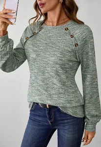 Detail van groen gemêleerd gebreid shirt met lange mouwen en schouderknopen