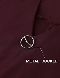 Close-up of the elegant gold metal buckle detail on a burgundy V-neck tunic blouse