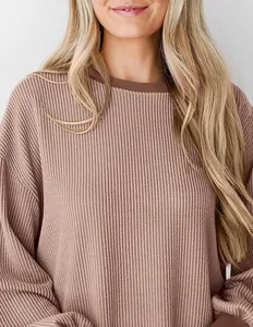 Detailopname van mauve wafelgebreide stof en de ronde halslijn van deze casual top